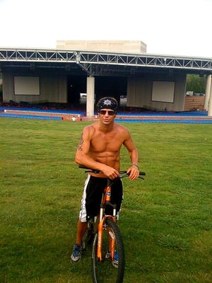Brett Michaels rides his mountain bike before a sound check at the PNC Music Pavilion Amphitheater in Charlotte, North Carolina.