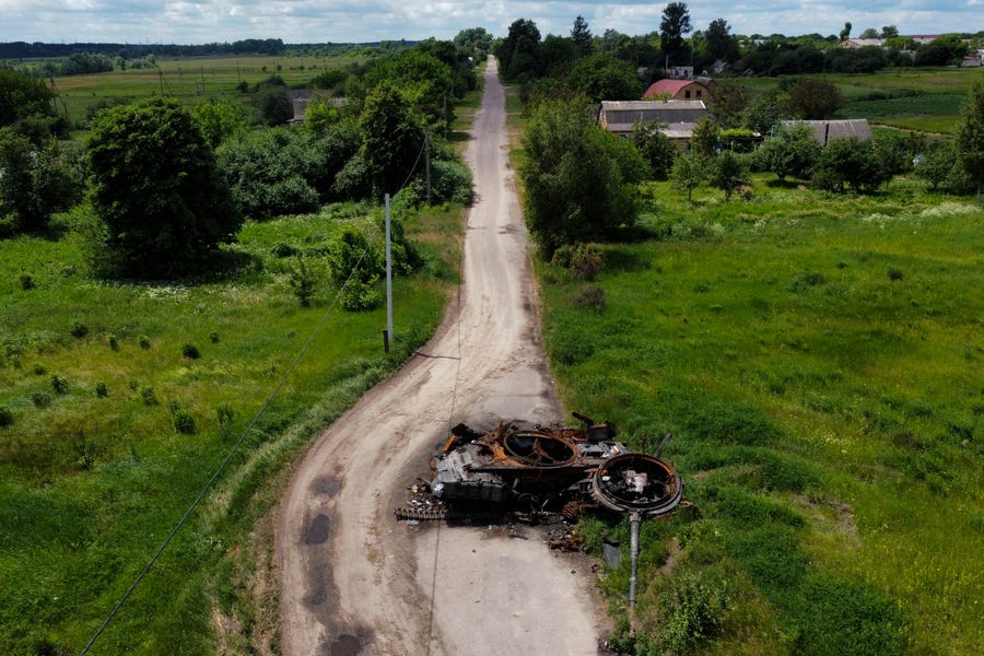 A ruined tank remains on a road in Lypivka, on the outskirts of Kyiv, Ukraine, Tuesday, June 14, 2022. Russia's invasion of Ukraine is spreading a deadly litter of mines, bombs and other explosive devices that will endanger civilian lives and limbs long after the fighting stops. 