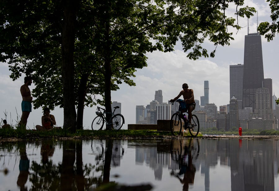 Bicyclists and sunbathers find some shade while temperatures in the 90s persist along the lakefront Wednesday, June 15, 2022 near North Avenue Beach in Chicago.