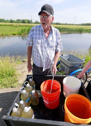 Green Acres resident Sonny McLaurin uses what he calls his "redneck water system" to gather water from a pond for residents to use in their trailers on Thursday. The seniors trailer park on state Route 89 had been without water since Monday's storm knocked out power and a generator failed to work. The management company rented a generator on Thursday. TOM E. PUSKAR/ASHLAND TIMES-GAZETTE