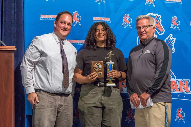 Aaron Mumby and Richard Smith present the Track and Field varsity club award and the Section V  Class B2 Track & Field -Shot Put & Discus Champion trophy to Adriana Rodriguez.