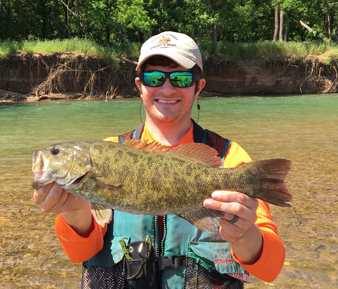 Andrew Taylor, associate professor of fisheries biology at the University of Central Oklahoma, holds the Neocho smallmouth bass from Baron Fork near Tahlequah, a fish native to the Ozarks in northeastern Oklahoma.