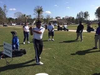 Members of 100 Black Men guide students on the correct golf swing.  PHOTO COURTESY OF JERRY JACKSON