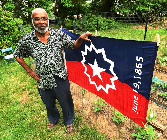 Ben Haith, 79, of Norwich, with the national Juneteenth flag he designed in the mid-1990's.