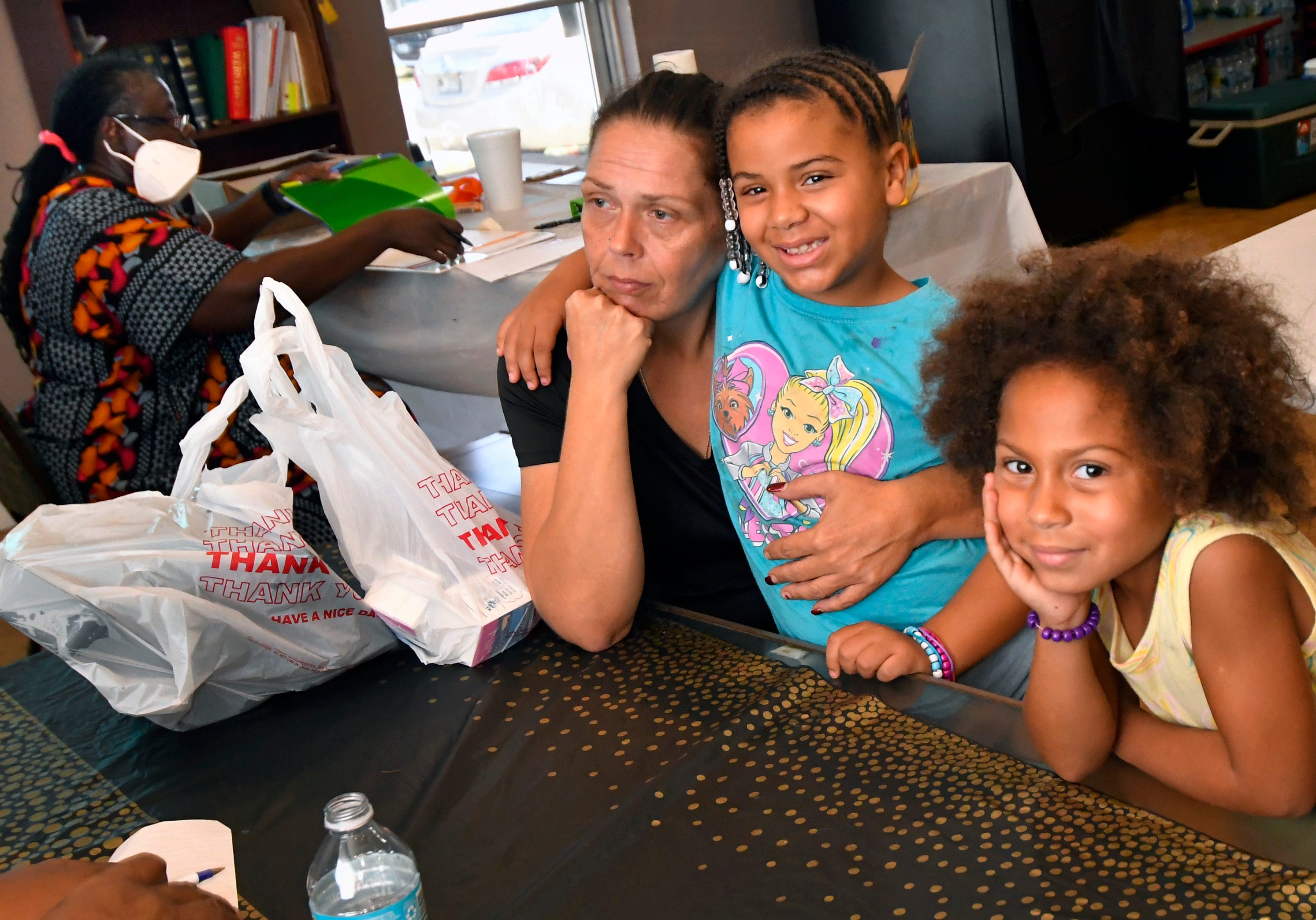 Mom of four Stacy Higginbotham is pictured with daughters Emilee, 7, and Kiara, 5,  at a Palm Bay Youth Read and Feed Program, where they picked up books and meals over the summer.