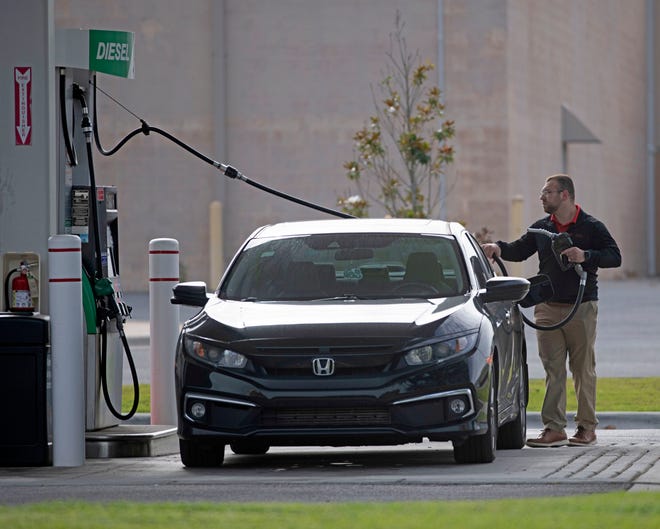 A motorist in Florida buys gas at a wholesale club June 16.
