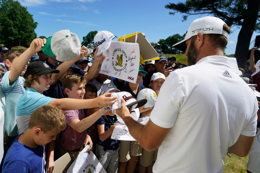 Dustin Johnson signs autographs after a practice round for the U.S. Open golf tournament at The Country Club, Wednesday, June 15, 2022, in Brookline, Massachusetts.
