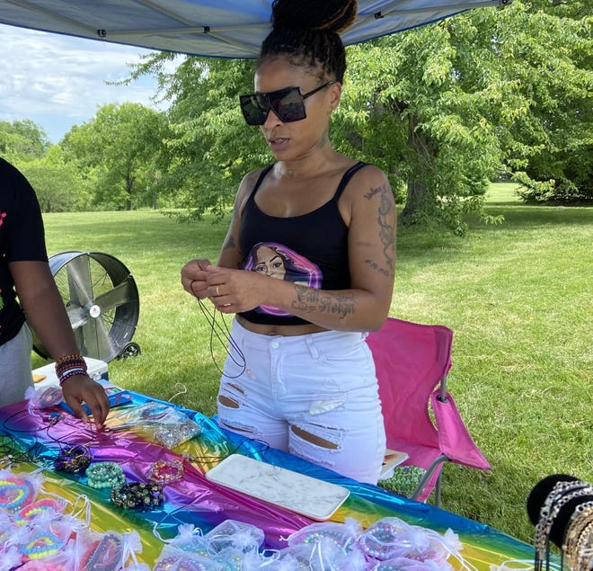 Angel Weir, owner of Cakez Customs, sets up her jewelry stand at a Juneteenth small business expo Friday afternoon.