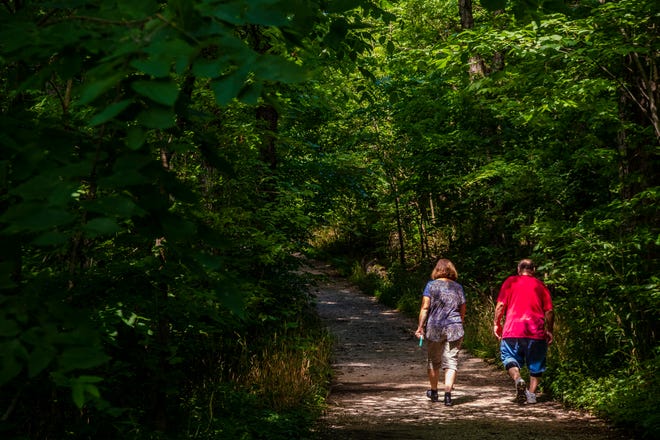 A couple walks the trail at Leonard Springs Nature Park Friday, July 24, 2020.