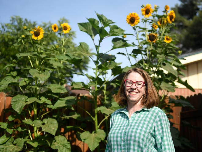 Becky Miller stands in front of her sunflowers, Friday, June 17, 2022. "To garden in Lubbock is to suffer," Miller says about West Texas' severe gardening conditions and the trial and error it takes to plant.