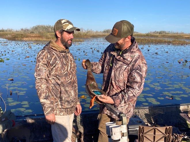 Harris Woodsby (left) and Chris Rumph are with a feral mallard.