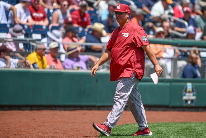 Jun 17, 2022; Omaha, NE, USA; Oklahoma Sooners head coach Skip Johnson walks to the dugout before the game against the Texas A&M Aggies at Charles Schwab Field. Mandatory Credit: Steven Branscombe-USA TODAY Sports