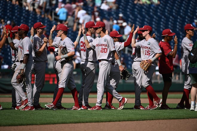 OU shortstop Peyton Graham (20) and second baseman Jackson Nicklaus (15) celebrate the Sooners' 13-8 win against Texas A&M with teammates Friday afternoon at Charles Schwab Field in Omaha, Neb.