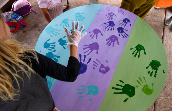 A former student leaves a handprint on a table at Camas Ridge Elementary School during a goodbye ceremony Thursday.