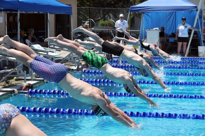 Swimmers dive into the pool during the Summer High Point Swim Meet Friday at the Aberdeen Aquatic Center.