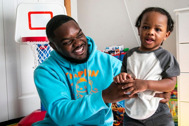 Davonte Foster, 22, poses for a photo with his son Legend, 1, Thursday at their home in Iowa City.