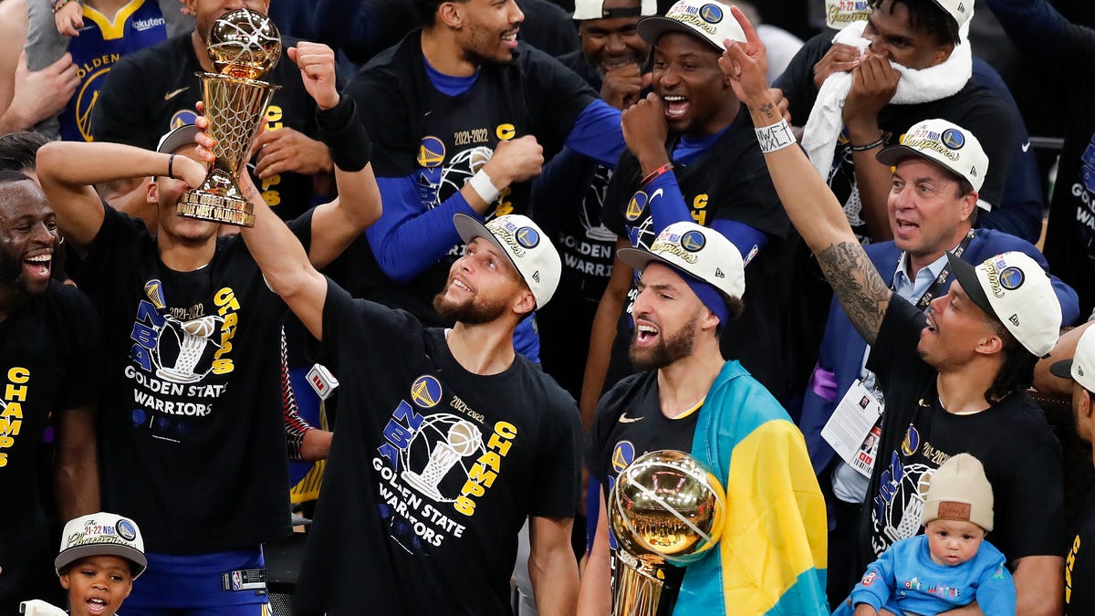 Stephen Curry holds up the Bill Russell Trophy after being selected the Most Valuable player after the Warriors beat the Celtics in Game 6.