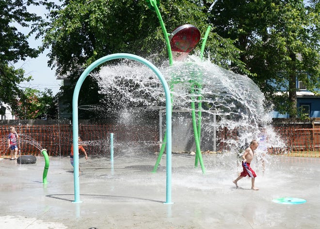 Kids are doused with water June 15, 2022, at the new splash pad at Parish Park in Adrian.
