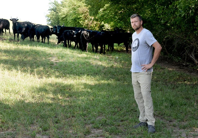 Clint Bland of Bland Family Farm in front of some of his cows Friday June 17, 2022.