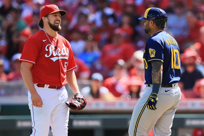 Cincinnati Reds starting pitcher Graham Ashcraft (51) smiles as he blocks the base path to first an tags out Milwaukee Brewers catcher Omar Narvaez (10) in the second inning of the MLB National League game between the Cincinnati Reds and the Milwaukee Brewers at Great American Ball Park in downtown Cincinnati on Saturday, June 18, 2022. The Brewers led 4-0 after four innings. 