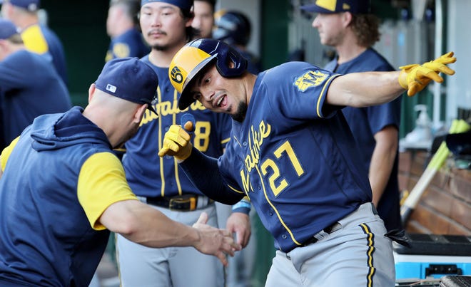 Willy Adames celebrates in the Brewers dugout with teammates after he smacked a solo home run against the Reds in the fifth inning on Friday night.
