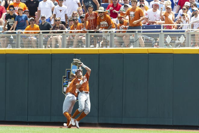 Texas center fielder Douglas Hodo III makes a catch close to right fielder Dylan Campbell in the first inning against Texas A&M in Sunday's 10-3 loss to the Aggies at the College World Series in Omaha, Neb. Texas' season ended at 47-22.