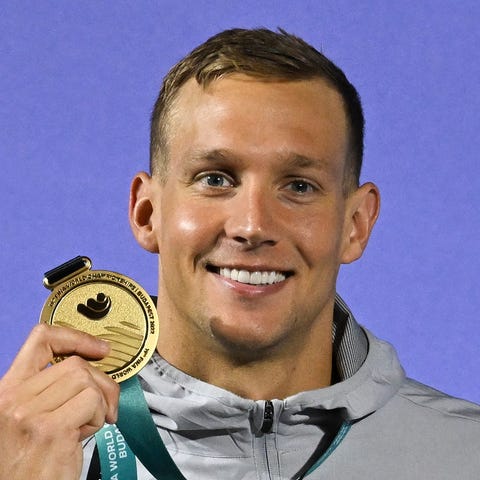 Caeleb Dressel poses with the gold medal after win