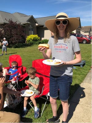 Katherine Meckewich has given her children, Michael, left, and Alex, their hot dogs. Now she is about to bite into her own at the Moving Milan Forward block party on Bluebird Lane in Milan. Provided by Martha A. Churchill