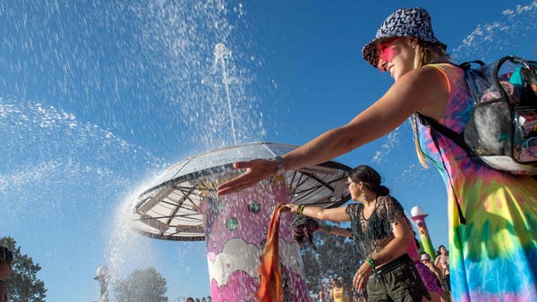 Festivalgoers refresh themselves from the heat dur