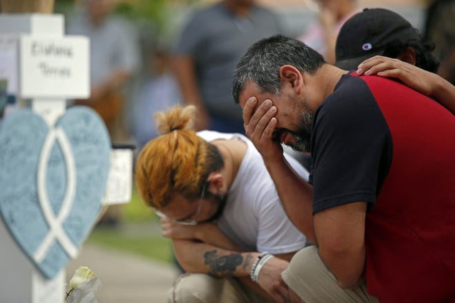 Vincent Salazar, right, father of Layla Salazar, weeps while kneeling in front of a cross with his daughter's name at a memorial site for the victims killed in the elementary school shooting in Uvalde, May 27.