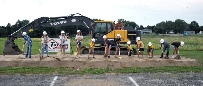 Twelve Southeast students turn the first shovels of dirt to start construction of the new school.