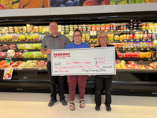 Perry Fareway Store Manager Travis Landgrebe and leading cashier Dariel McNamara present a check to Perry Chamber of Commerce Executive Director Lynsi Pasutti following the round-up event for the Fourth of July Fireworks Drive.