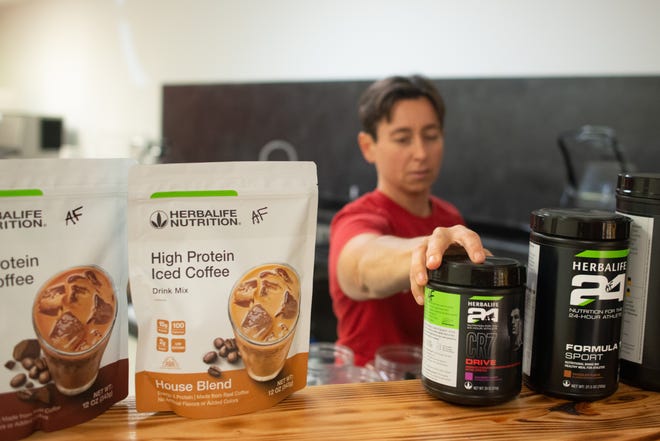 Stine Taylor, a partner of North Nutrition at 1835 N.W. Topeka Blvd., places a selection of Herbalife Nutrition products on the counter last week as she prepared for the store's opening.