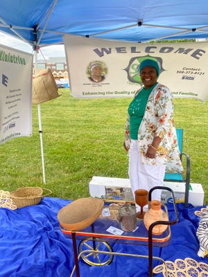 Ketelie Altena poses with artifacts from Haiti at a Juneteenth celebration in Institute Park.