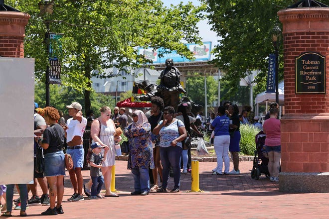 Customers line up to buy food from a vendor during the Juneteenth festival Monday, June 20, 2022, in Wilmington.