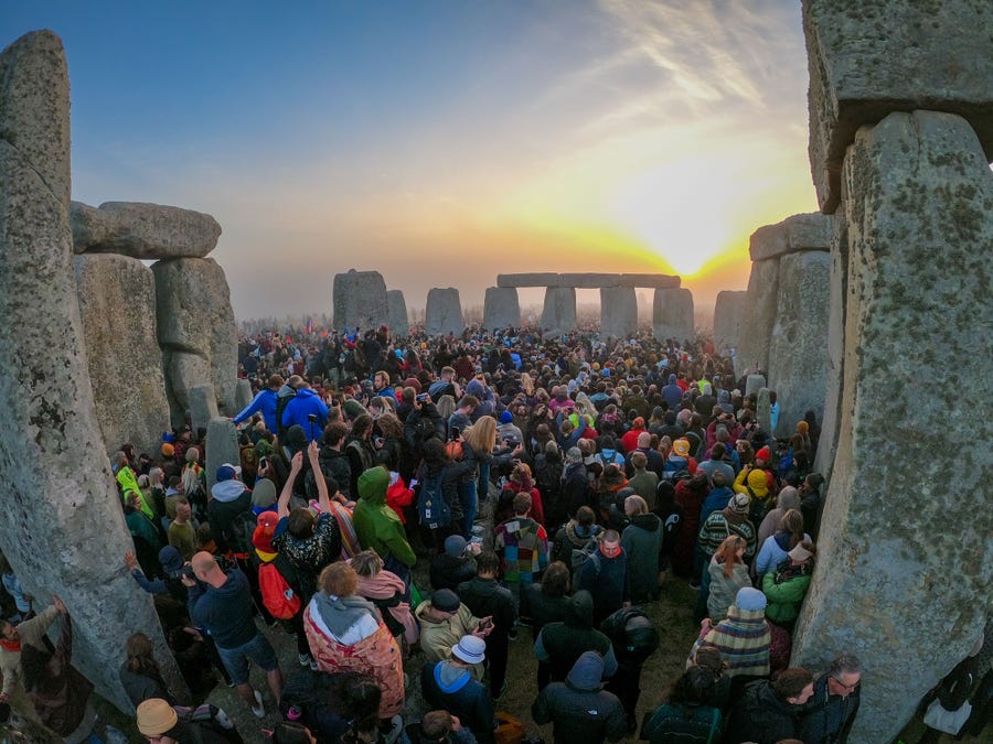 People gather for sunrise at Stonehenge, on June 21, 2022 in Wiltshire, England. In England, hundreds of people travel to the ancient site Stonehenge for the first day of summer. Solstice observations there have been going on annually for thousands of years.