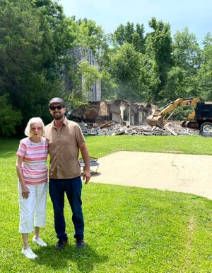 Ruth Root Benton, daughter of WJDX’s original chief engineer Percy Root, stands with new transmitter building owner Scott Allen as demolition work proceeds.