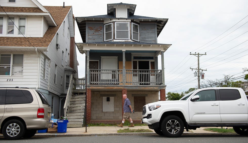 Robert Lukasiewicz walks in front of his family's Atlantic City home that was heavily damaged by Superstorm Sandy.  Inflation is making the costs to repair the home even more expensive.  