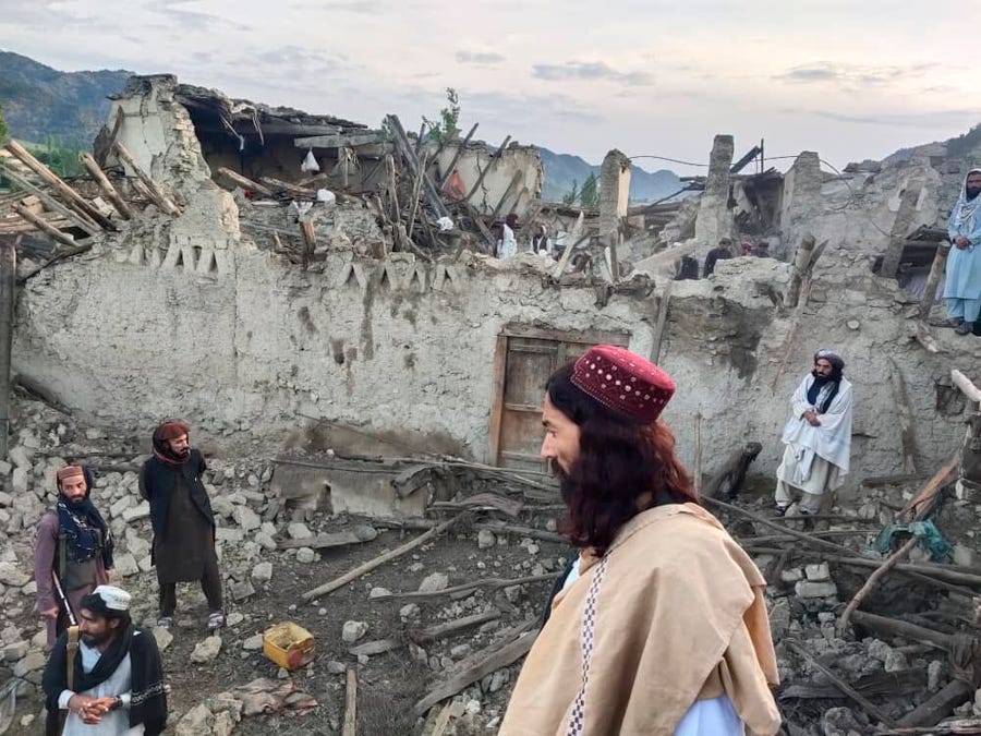 In this photo released by the state-run news agency Bakhtar, Afghans look at destruction caused by an earthquake in the province of Paktika, eastern Afghanistan, Wednesday, June 22, 2022.