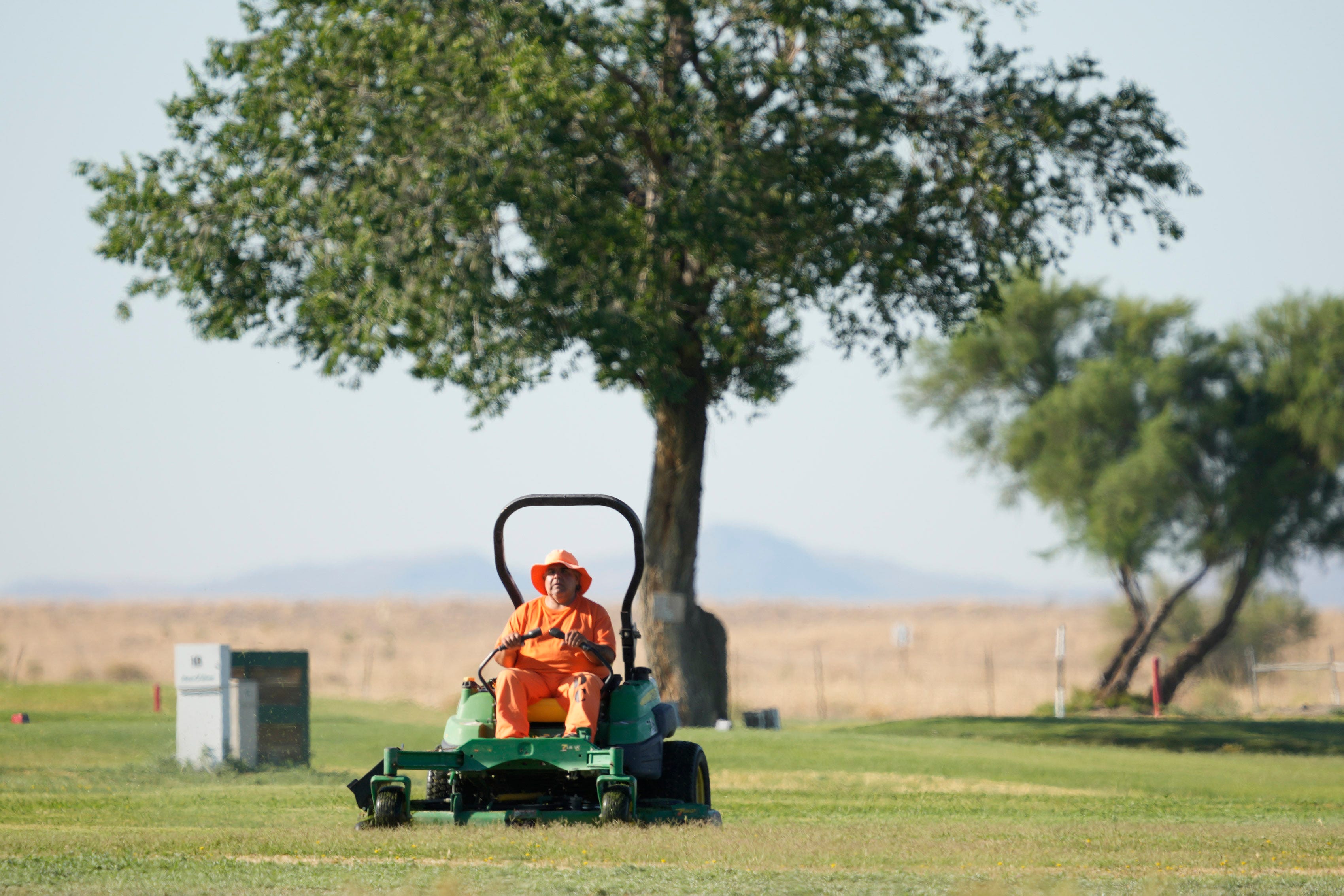 A prisoner mows the lawn at the Twin Lakes Municipal Golf Course in Willcox.
