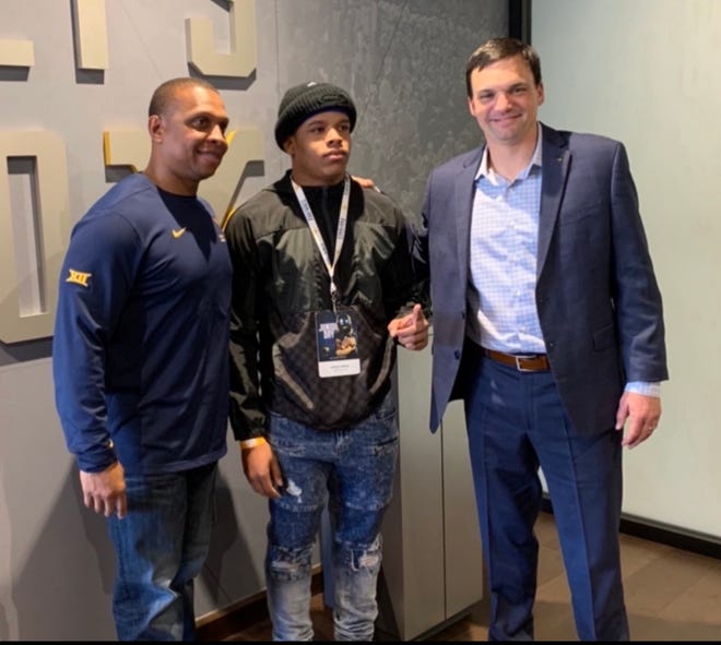 Recent William Penn High School graduate and football star Jahiem White with the West Virginia University coaches who recruited him.