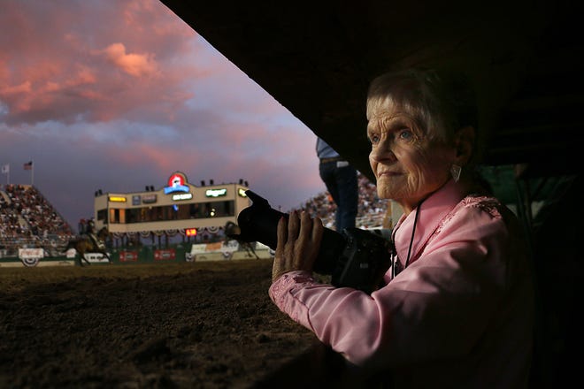 Longtime Reno photojournalist Marilyn Newton looks to make a photograph during sunset at the Reno Rodeo on June 22, 2022. Newton has covered the Reno Rodeo since 1963.