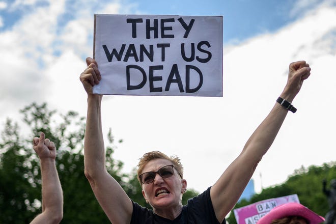 A protester holds a sign that reads "They Want Us Dead" during a protest against gun violence by the activist group "Gays against Guns" in New York City on June 23, 2022.