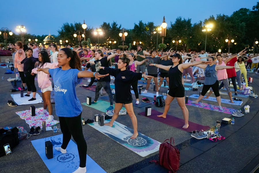 Nearly 2,000 Cast Members practice sunrise yoga celebrating International Yoga Day in front of Cinderella Castle at the Magic Kingdom Park at Walt Disney World Tuesday, June 21, 2022, in Lake Buena Vista, Florida.