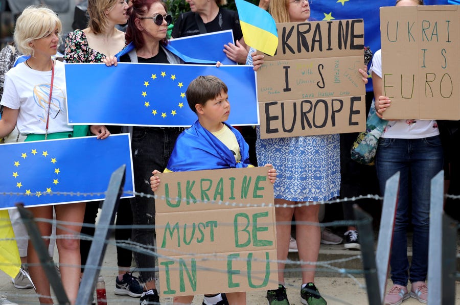 Protestors in support of Ukraine stand with signs and EU flags during a demonstration outside of an EU summit in Brussels, Thursday, June 23, 2022.