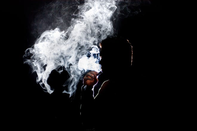 A man smokes a Juul electronic cigarette.