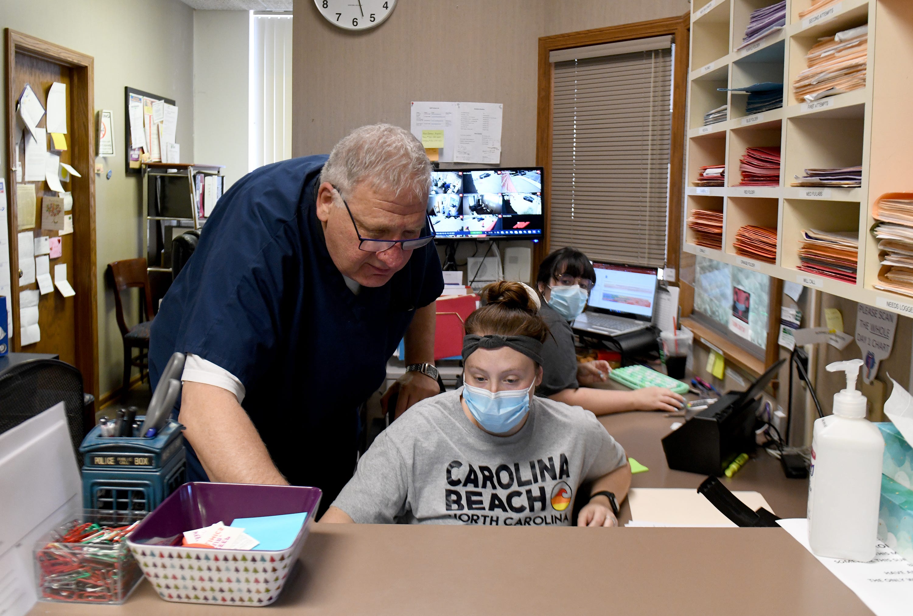 Dr. David Burkons consults with medical assistant Abby Ruggles as she juggles calls into Northeast Ohio Women's Center in Cuyahoga Falls following the overturning of Roe v. Wade in June.