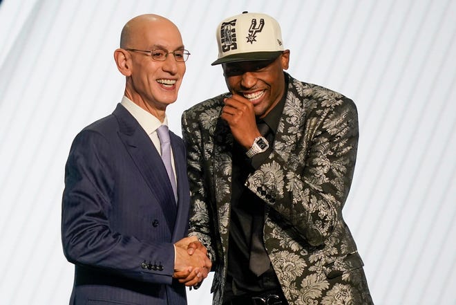 Malaki Branham reacts as he shakes hands with NBA commissioner Adam Silver after being selected 20th in the NBA draft.