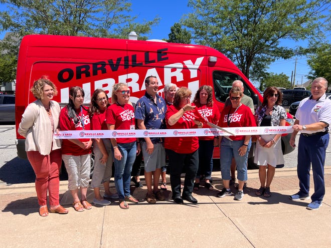 On hand to kick off the Library on the Go initiative at the Orrville Public Library on Thursday were Lori Reinbolt (left), Wendy Ensor, Tammy Daubner, Jenny McFarren, Amy Spinelli, Shane Scarbrough, Lisa Joyce, Daphne Silchuk-Ashcraft, Corrie Yoder, Denise Odenkirk, Rich Thomas, Michelle Hedberg and Mayor Dave Handwerk.
