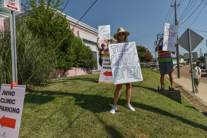 Libby Spence, a clinic escort, holds a sign outside of the Jackson Women's Health Organization after the U.S. Supreme Court overturned Roe v. Wade in Jackson, Miss., Friday, June 24, 2022.